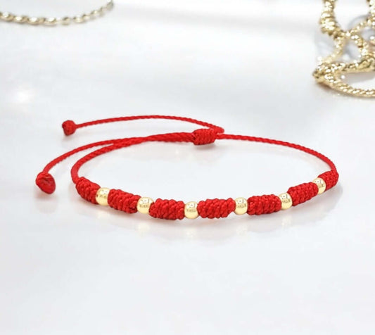 Protect your baby with the 7-Knot Bracelet featuring 14k gold beads.